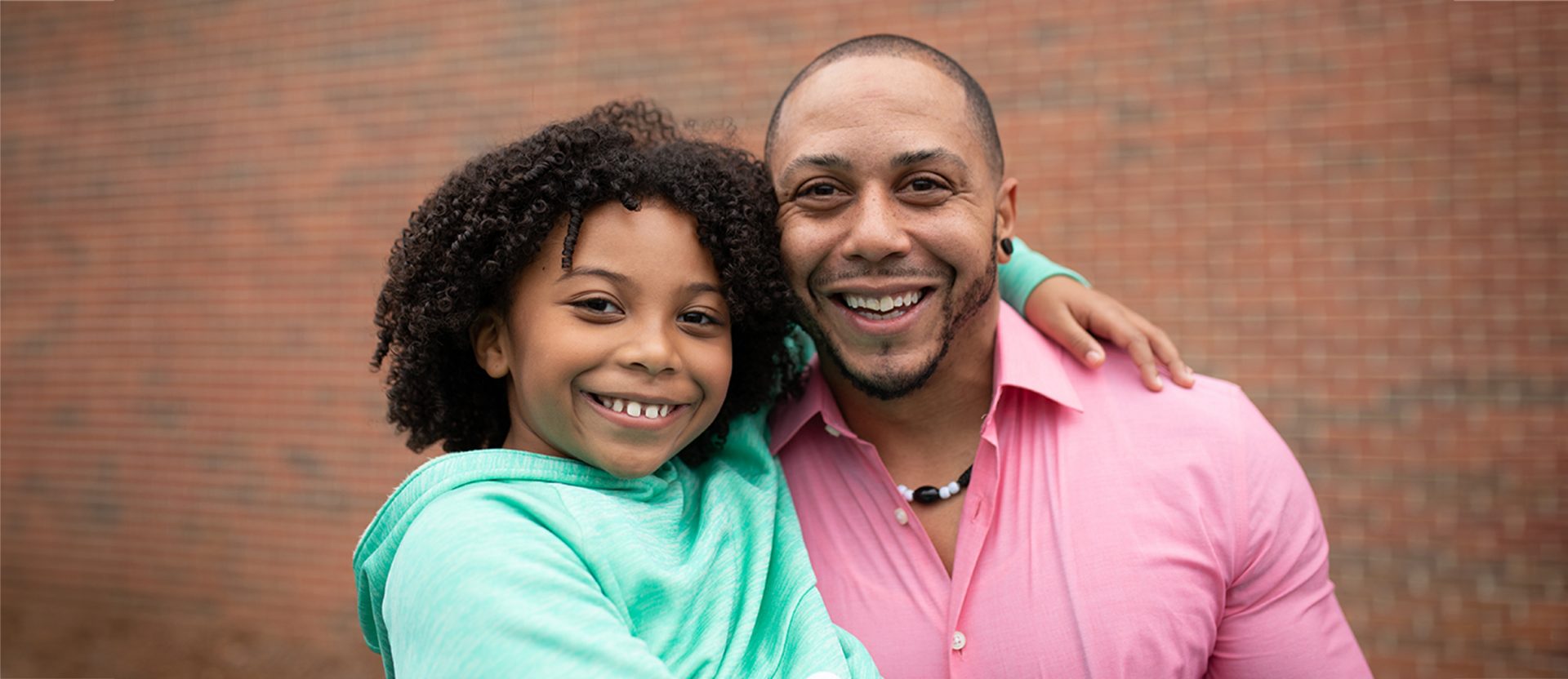 A Girl Scout with her arm around her dad's neck