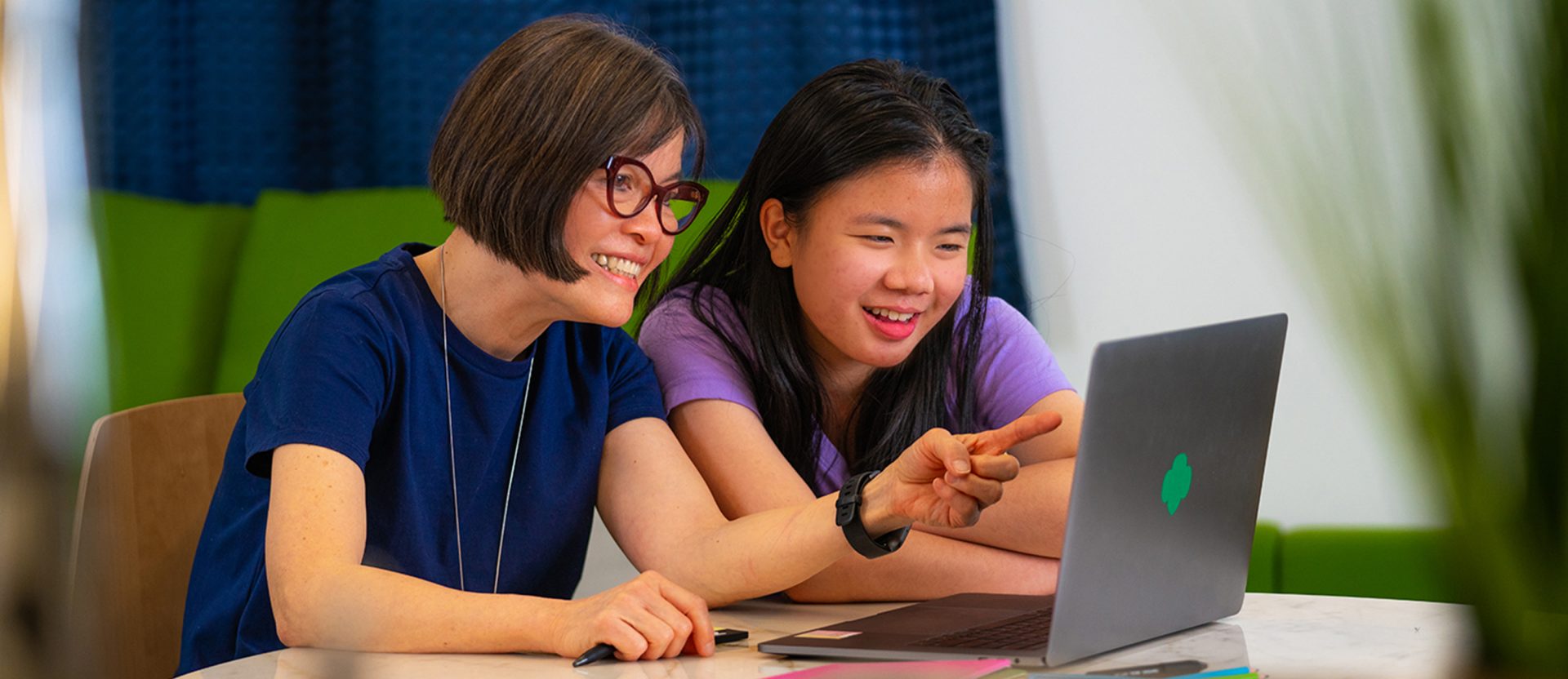 A volunteer working on a laptop with a Girl Scout
