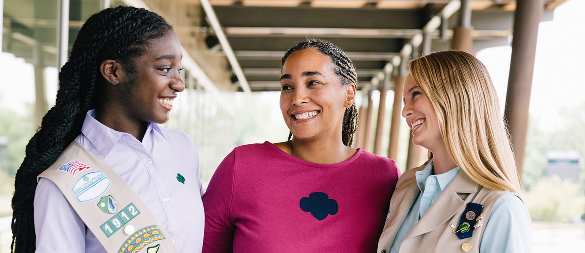 two older Girl Scouts with their Leader in the center
