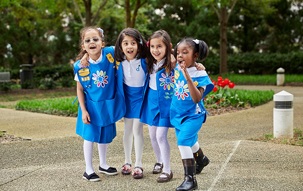 Group of girl scout daisies hugging and smiling at camera. Group of girl scout daisies hugging and smiling at camera.